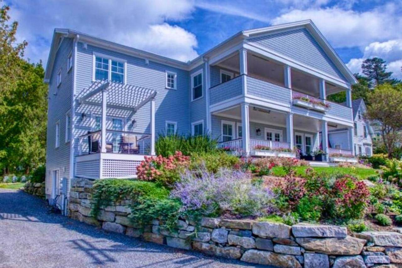 a large blue house with a stone wall at Harbor's End, Unit A in Boothbay Harbor