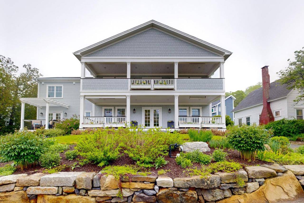 a large white house with a stone wall at Harbor's End Unit B in Boothbay Harbor