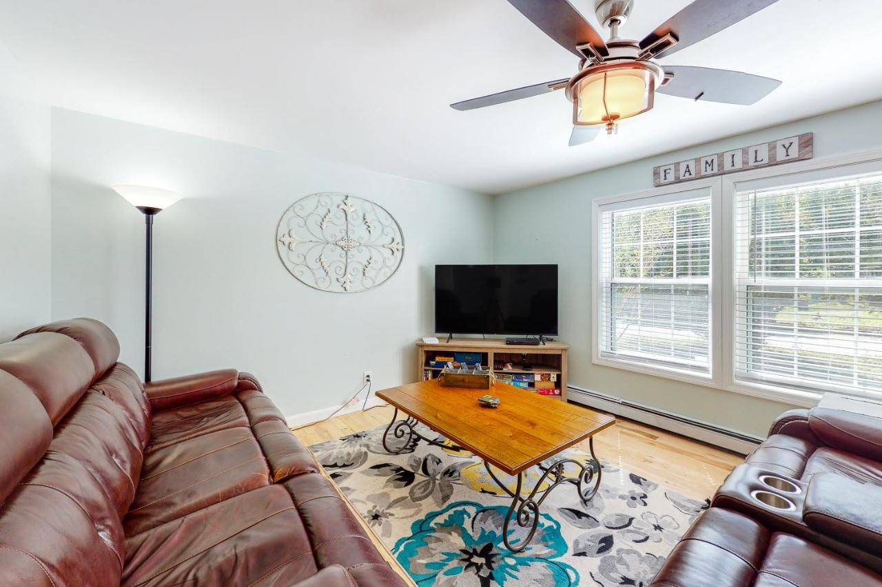 a living room with a couch and a table at Mabel's Maine Cottage in Boothbay Harbor