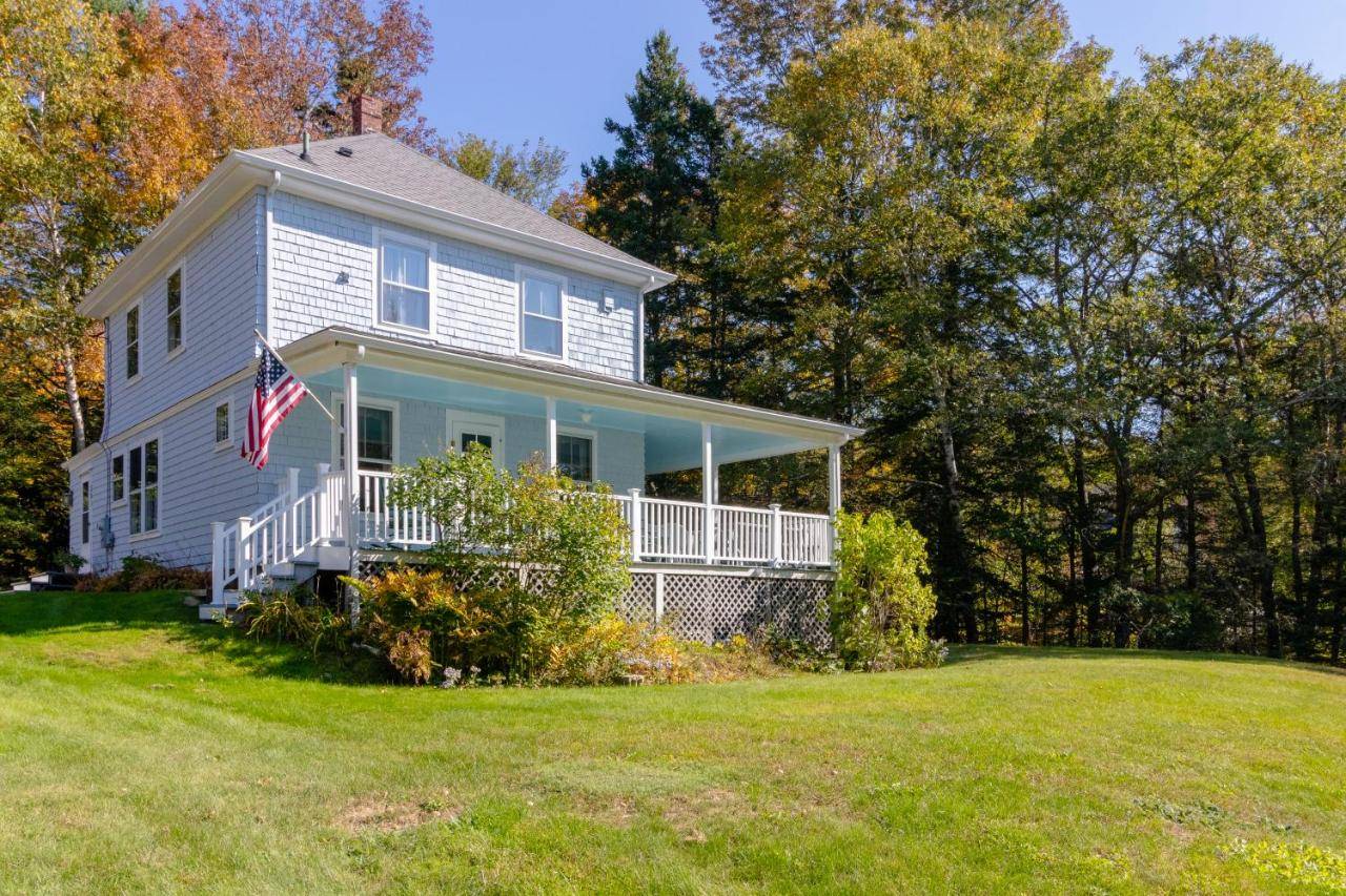 a white house with an american flag on a yard at Maine Stay in Boothbay Harbor