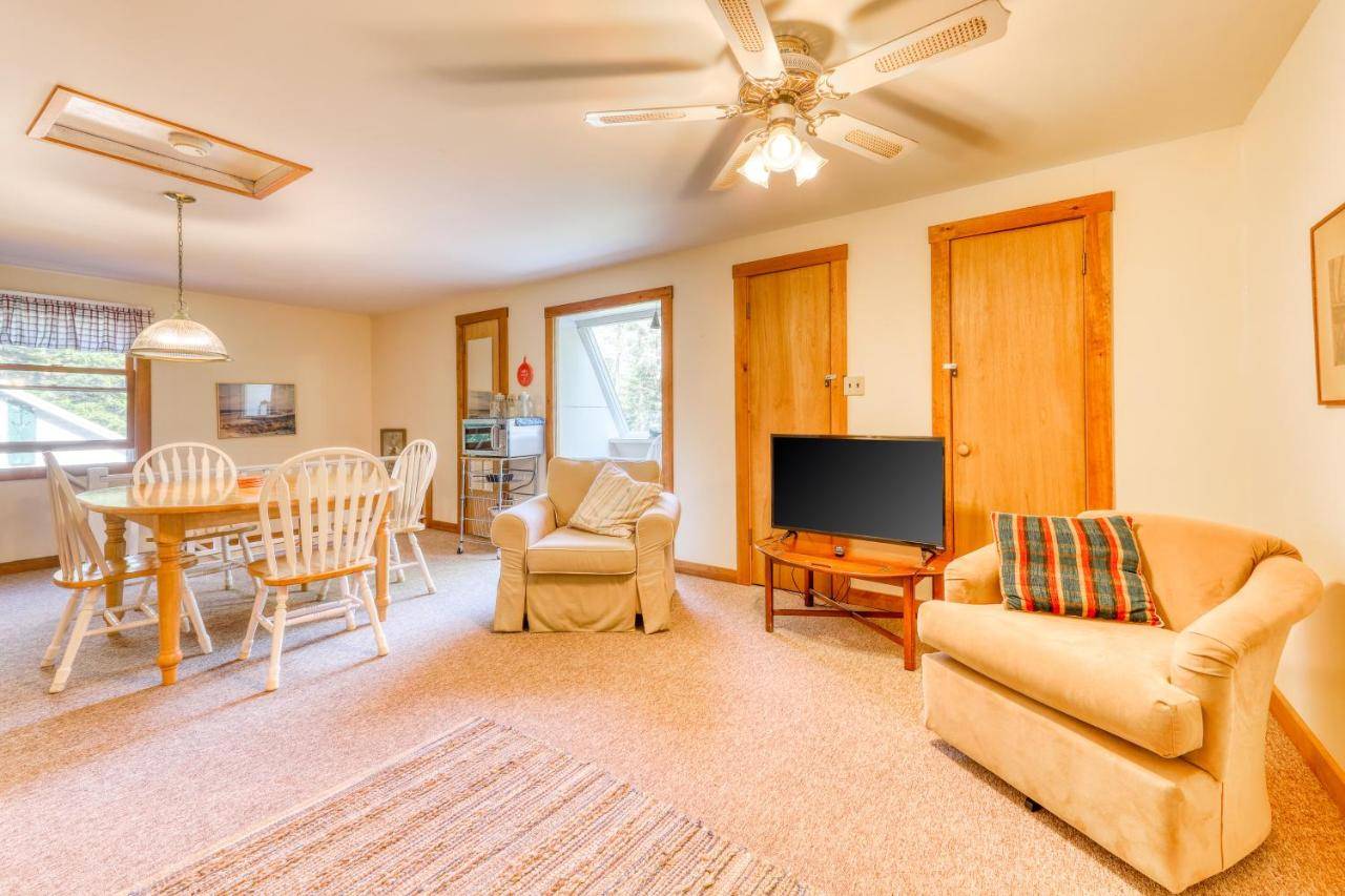 a living room with a tv and a table and chairs at Overlook in Boothbay Harbor