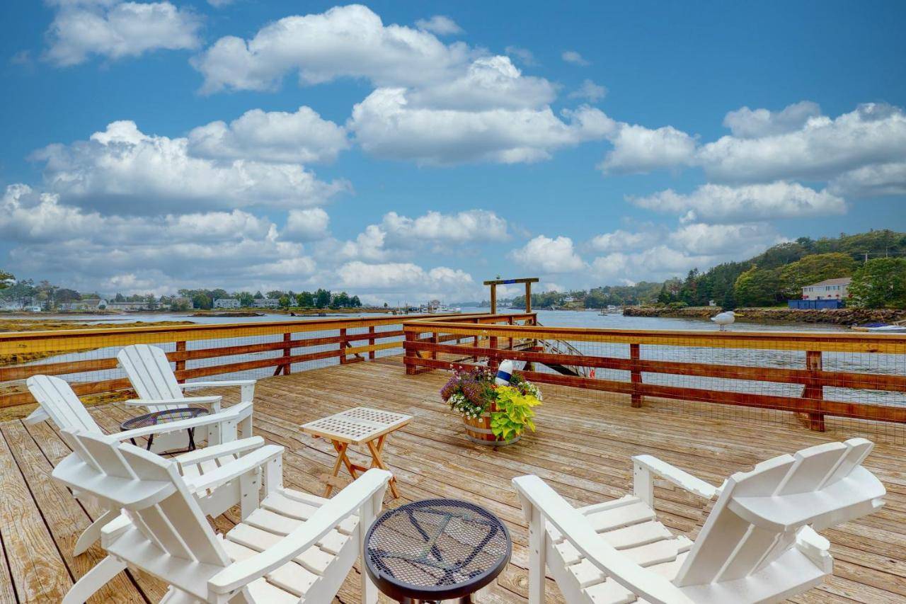a group of white chairs and a table on a deck at Portside in Boothbay Harbor