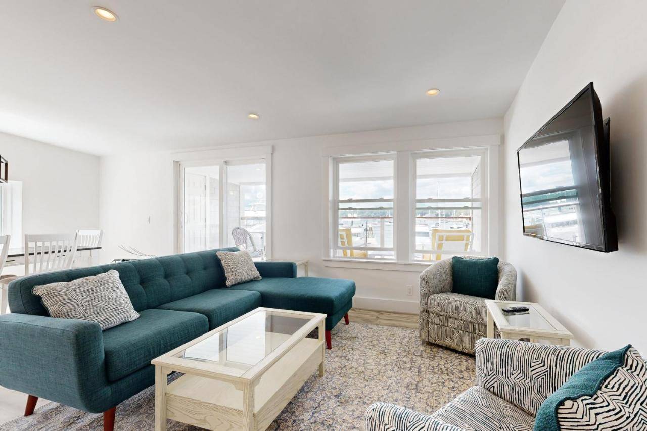 a living room with a blue couch and a tv at Sunset Sanctuary in Boothbay Harbor