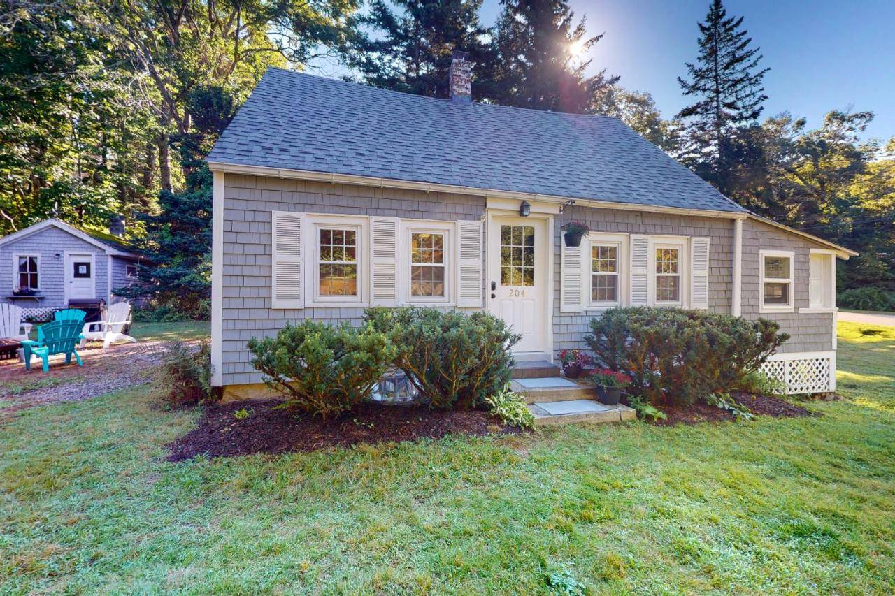 a small house in a yard with some bushes at The Cove in Boothbay Harbor