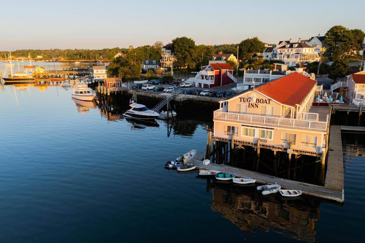 a building on a dock with boats in the water at Tugboat Inn in Boothbay Harbor