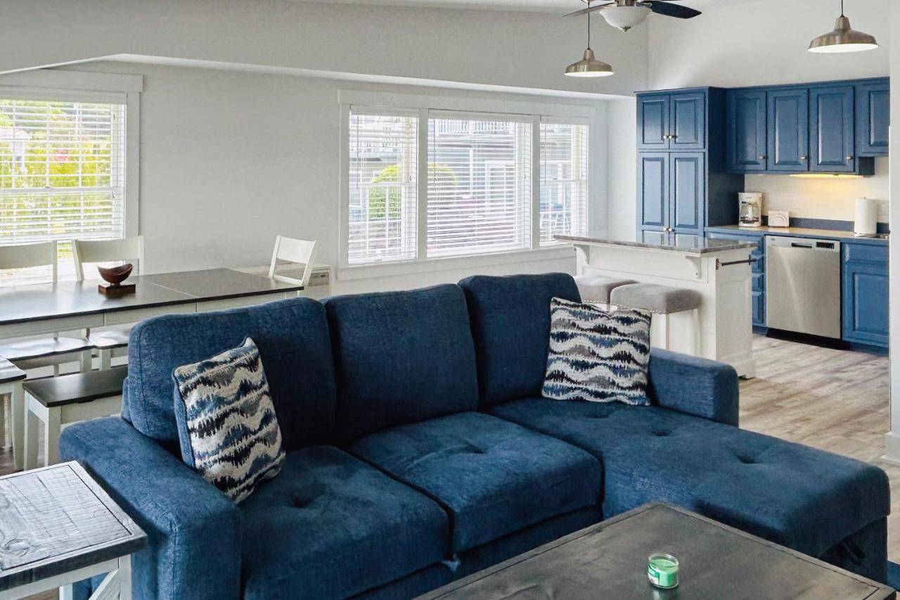 a living room with a blue couch and a kitchen at Whale's Tale in Boothbay Harbor