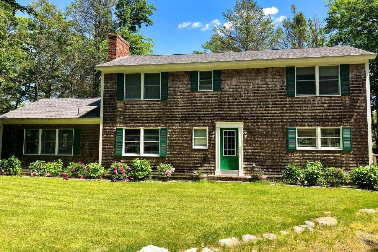 a brick house with a green door and a yard at Private Waterfront Retreat in Boothbay