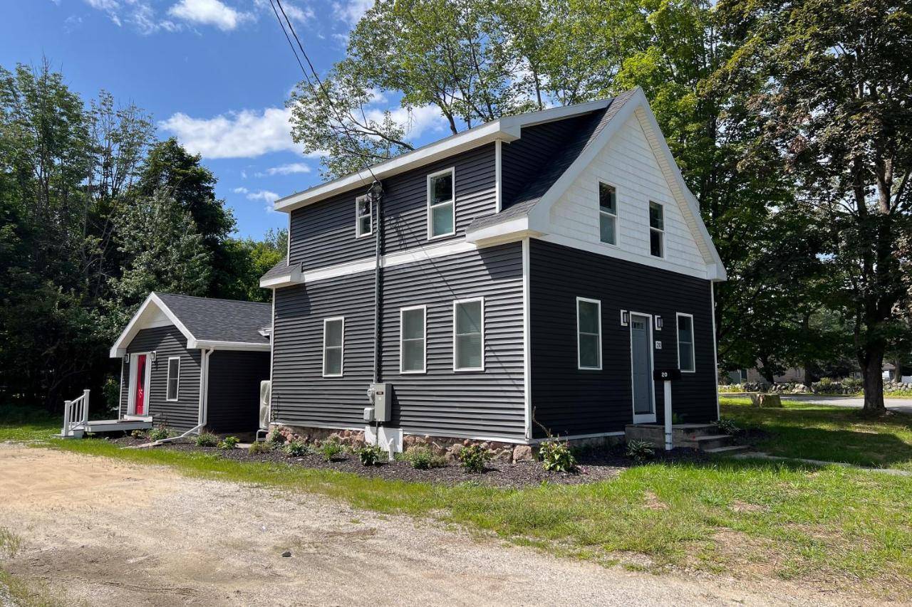 a black and white house with a red door at Eagle's Nest in Bridgton
