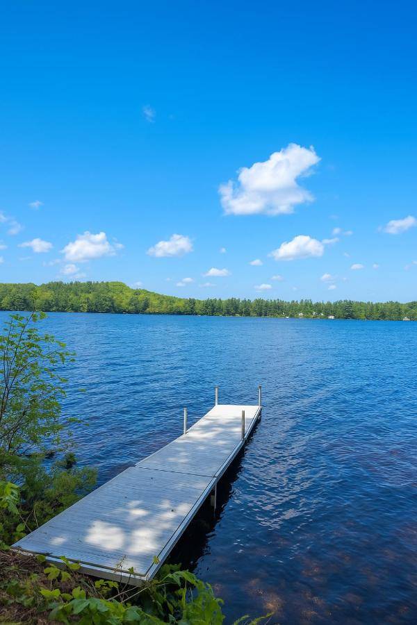 a dock in the middle of a large body of water at Gorgeous House on Highland Lake in Bridgton