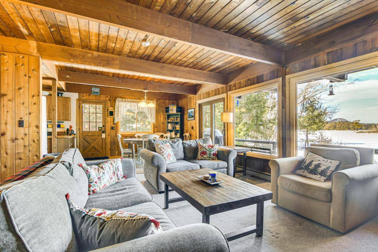 a living room with couches and a table at Million-Dollar View Waterfront Cabin in Bridgton! in Bridgton