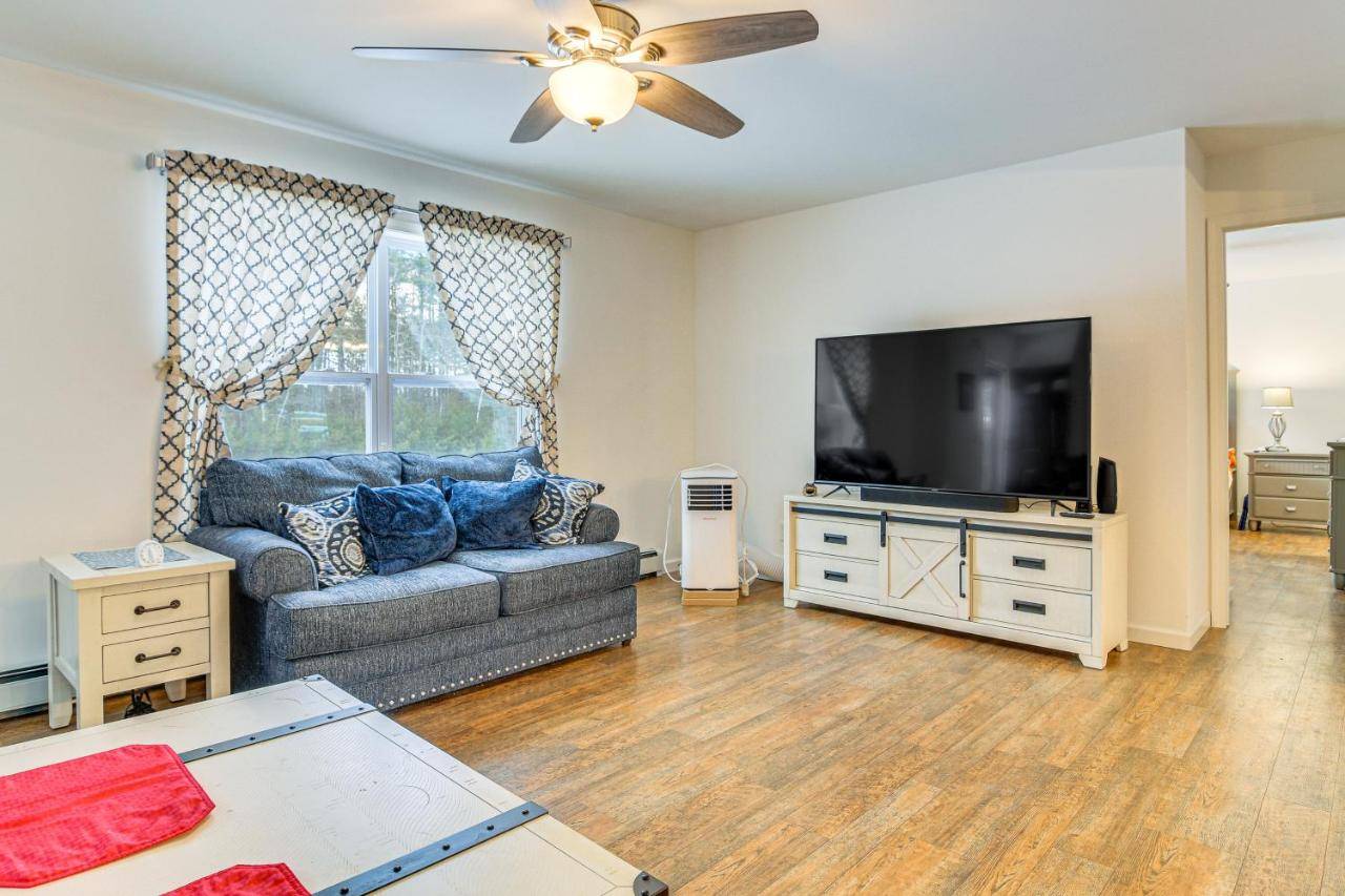 a living room with a couch and a flat screen tv at Near Skiing Serene Harrison Retreat with Fire Pit in Bridgton