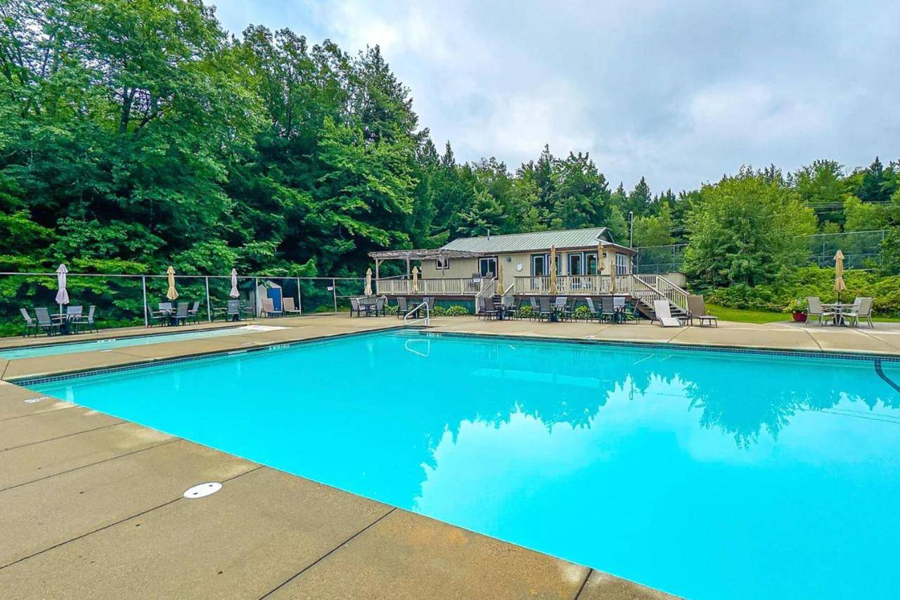 a large blue swimming pool in front of a house at Pleasant Mountain Ski Chalet in Bridgton