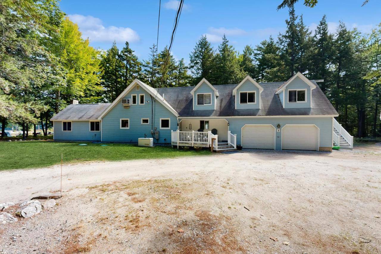 a large blue house with a garage at Ski & Splash Retreat in Bridgton