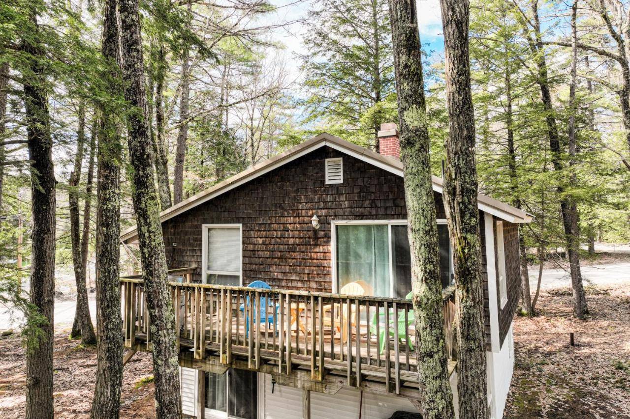 a cabin in the woods with a deck at The Good Knight in Bridgton