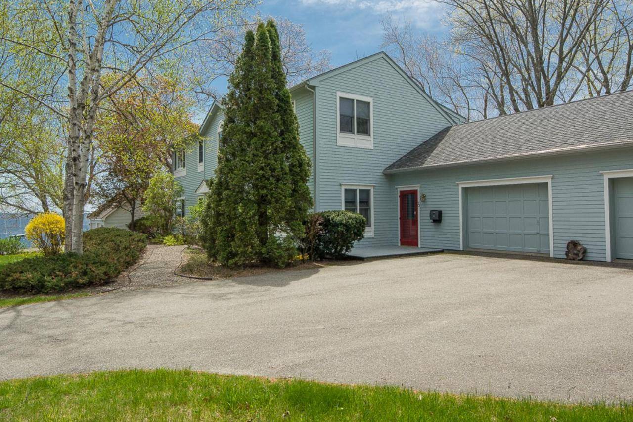 a blue house with a garage and a driveway at Camden Harbor View House in Camden