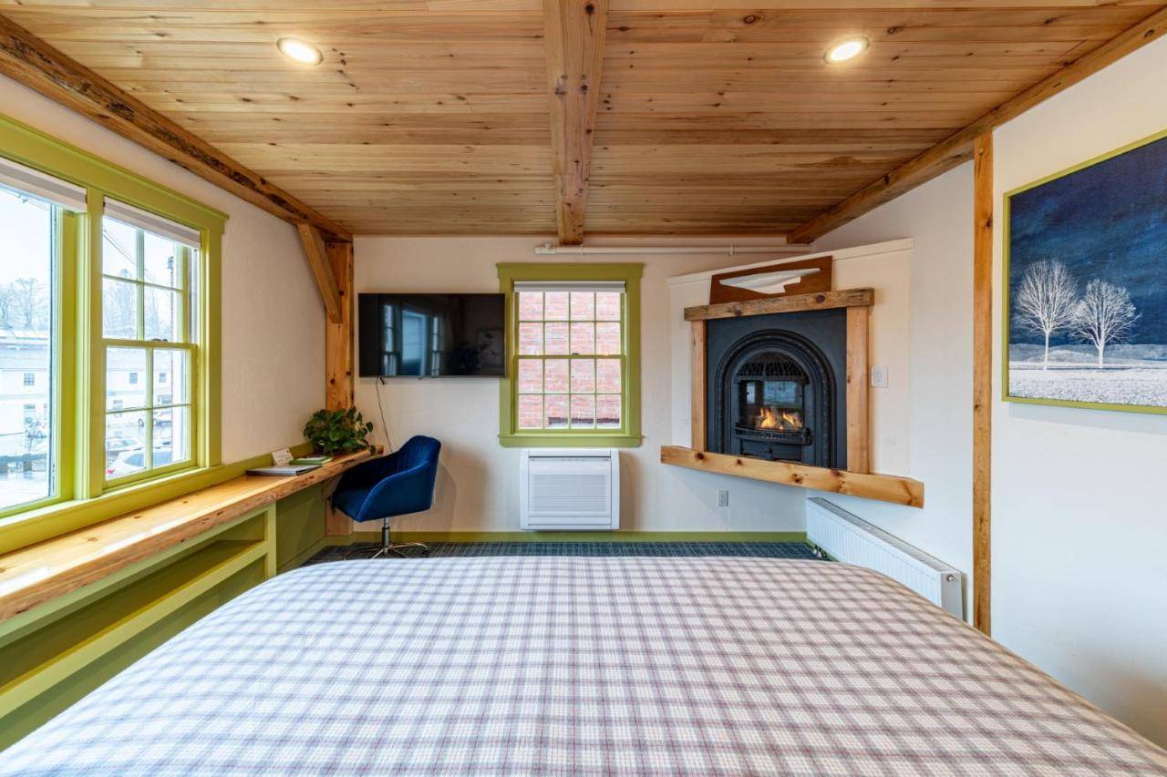 a bedroom with a bed and a fireplace at Downtown Camden Hotel in Camden