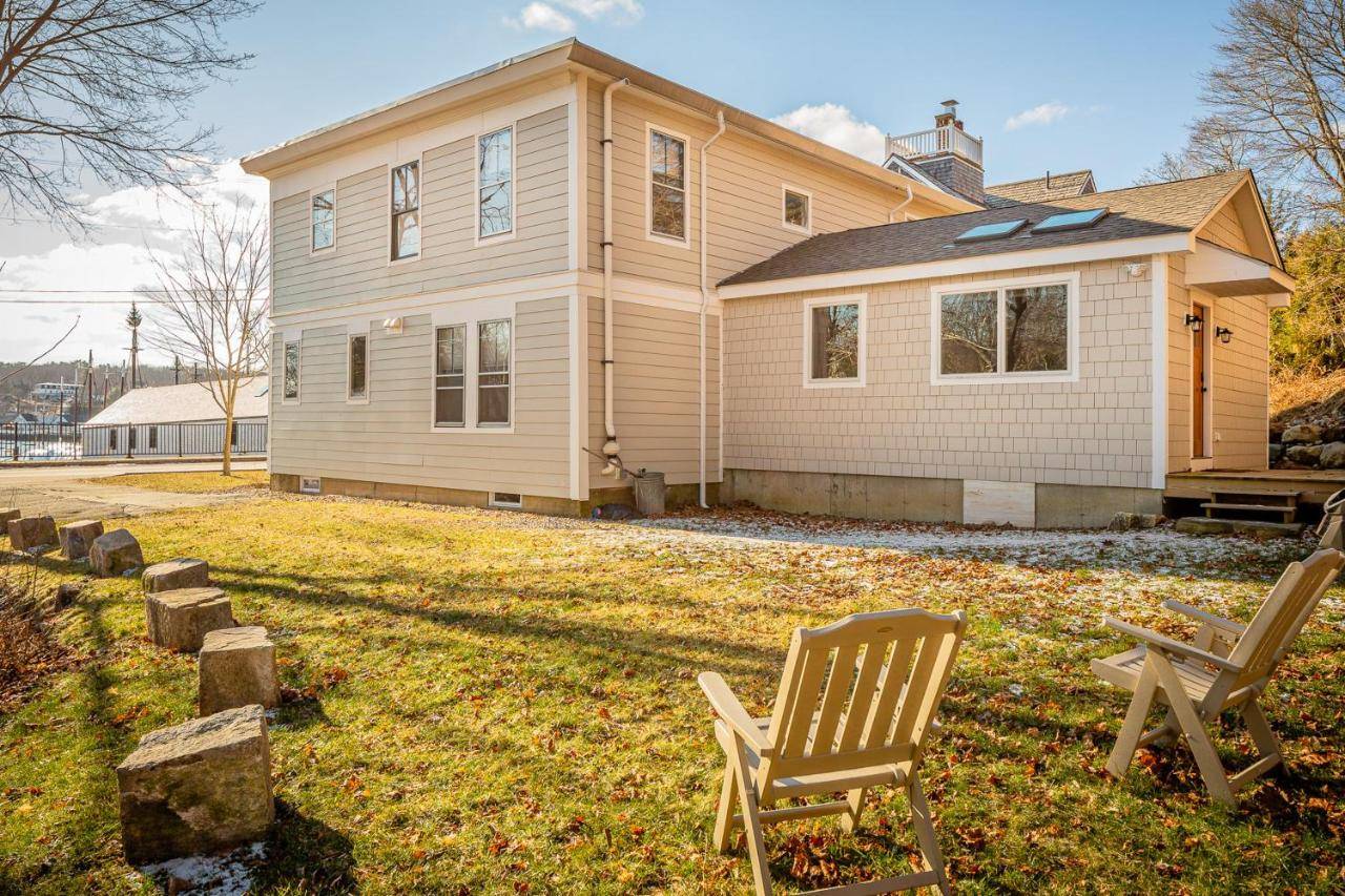 a house with two lawn chairs in front of it at Harborwalk Upper in Camden