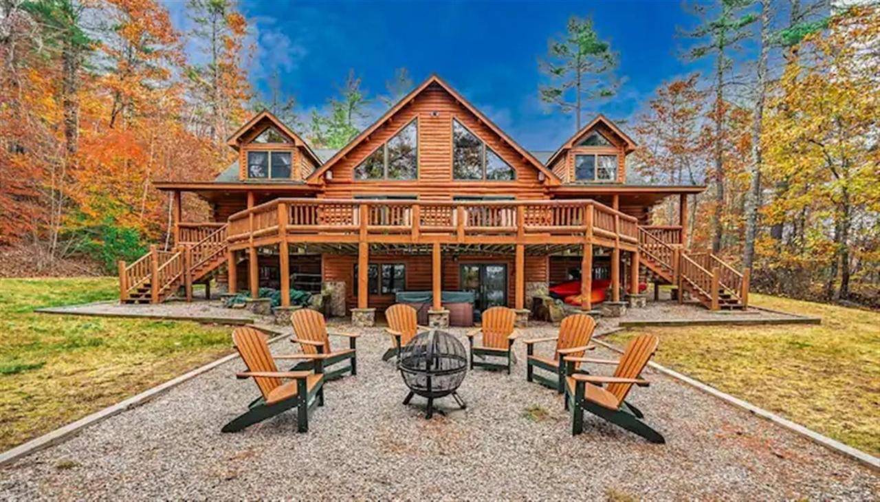 a large log home with chairs and a grill at PERLEY POND LODGE LIMIT 14 villa in Denmark