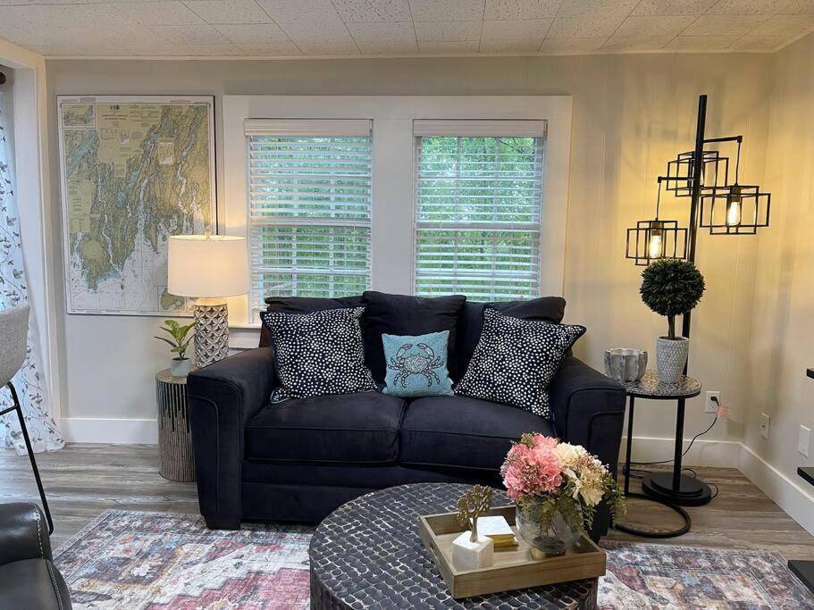a living room with a blue couch and a table at Cheerful 1 Bedroom Cottage Close to Everything 2 in Edgecomb
