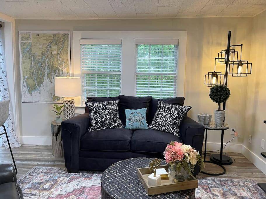 a living room with a blue couch and a table at Cheerful 1 Bedroom Cottage Close to Everything 5 in Edgecomb