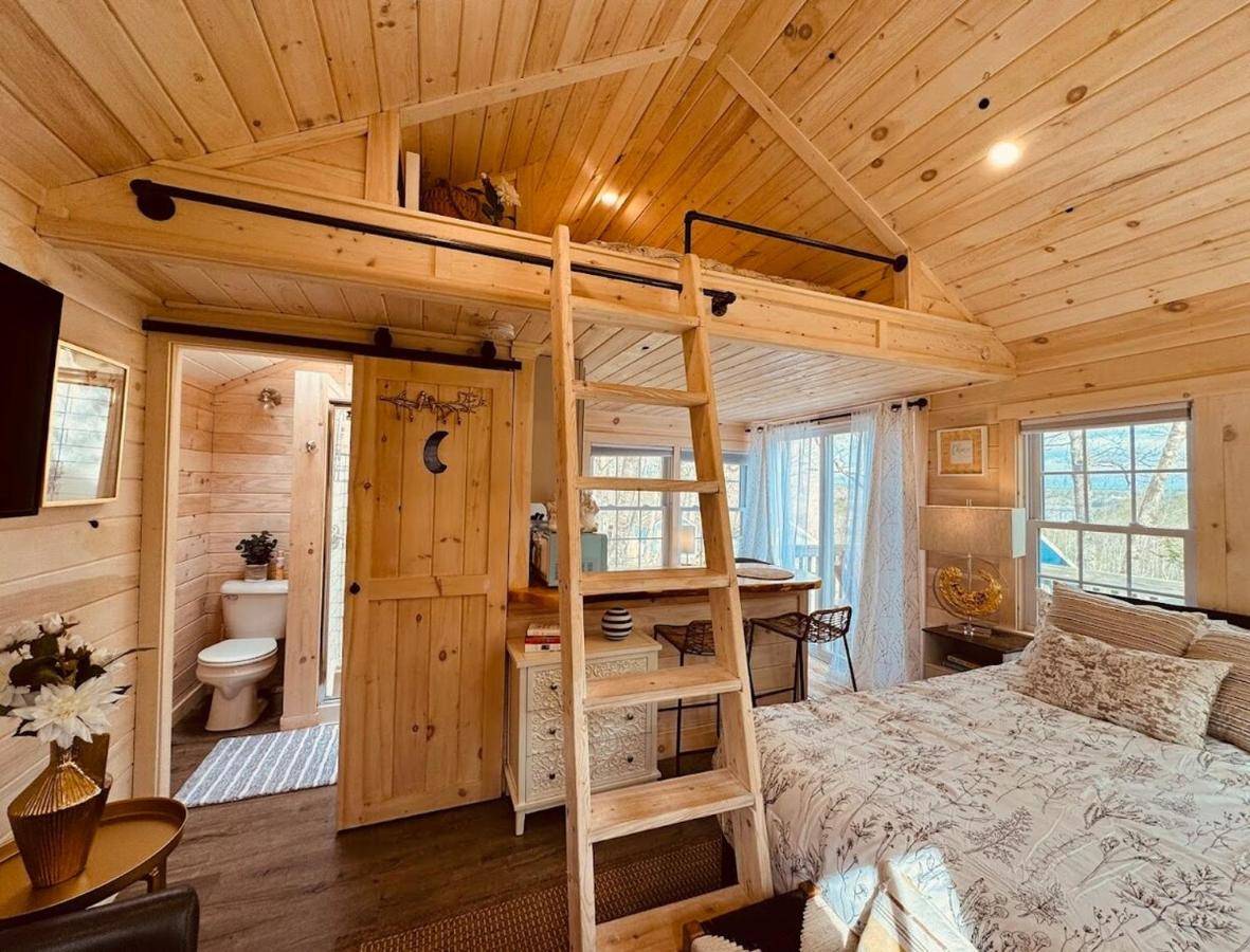 a bedroom with a bunk bed in a wooden cabin at Cheerful Cottage with Loft 9 in Edgecomb