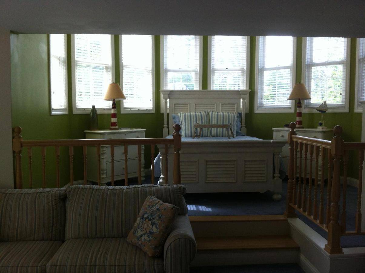 a living room with a couch and a bed and windows at Romantic riverside Sheepscot Harbour Studio #308 in Edgecomb