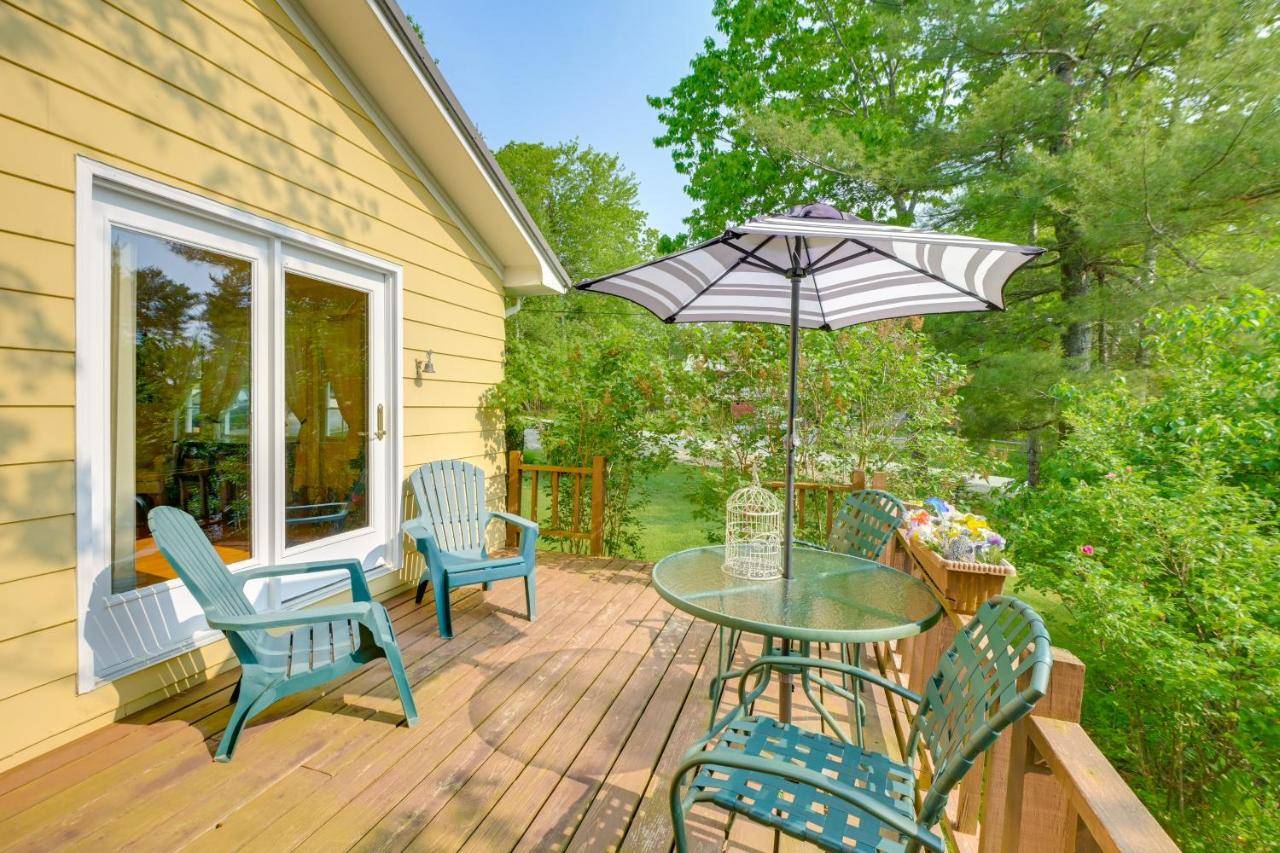 a patio with a table and chairs and an umbrella at 1 Mi to Main St Charming Elsworth Home with Yard! in Ellsworth