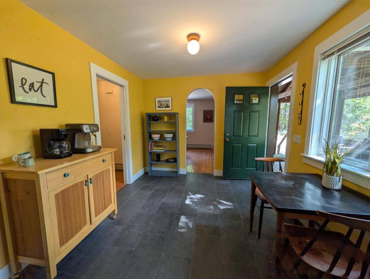 a kitchen with yellow walls and a green door at Acadia Hiking Hideaway 1 dog ok sleeps 6 family in Ellsworth