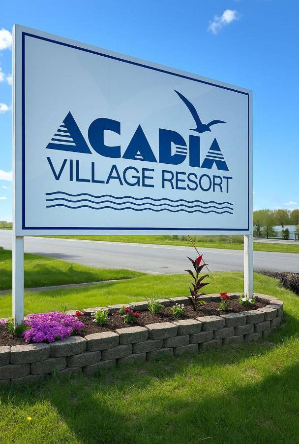 a sign for aalesilla village resort on a road at Acadia Village Resort in Ellsworth