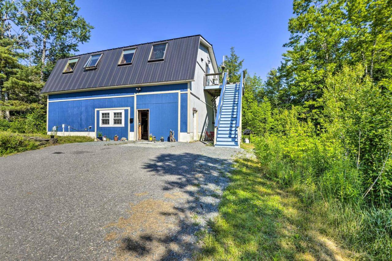 a blue house with a garage and a driveway at Charming Studio about 20 Mi to Acadia Natl Park! in Ellsworth