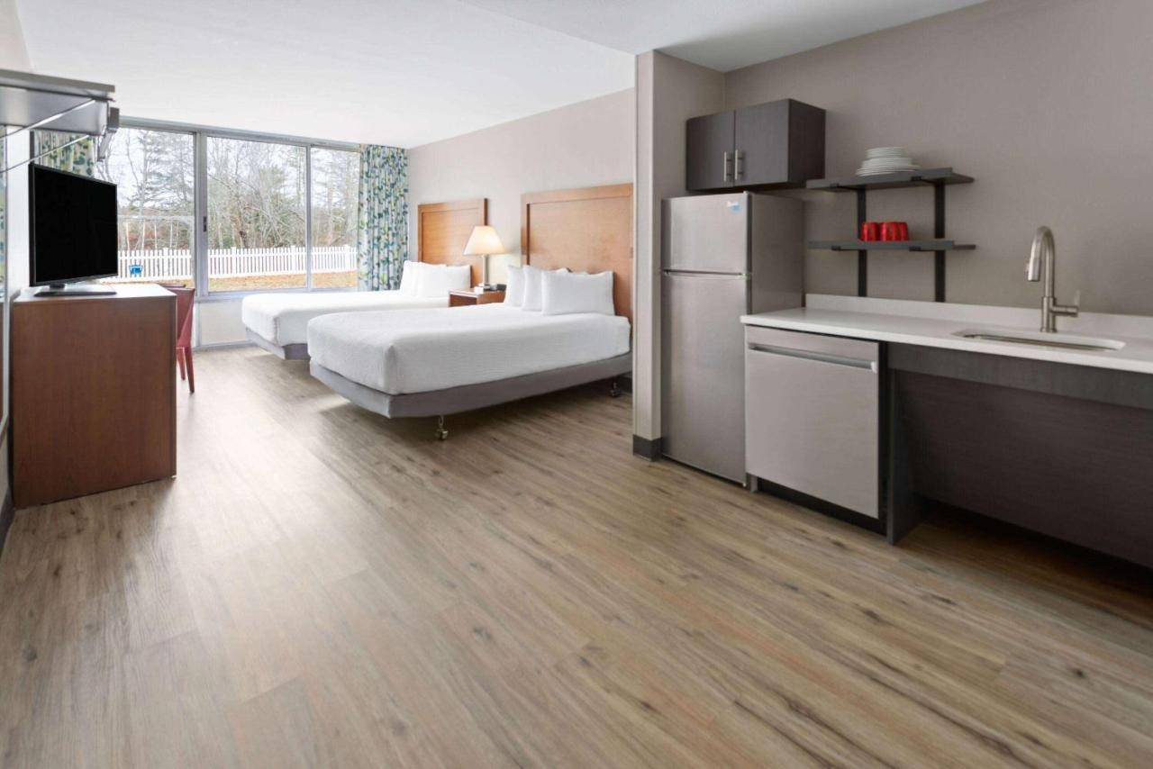 a large hotel room with two beds and a kitchen at Hawthorn Extended Stay by Wyndham Ellsworth Bar Harbor in Ellsworth