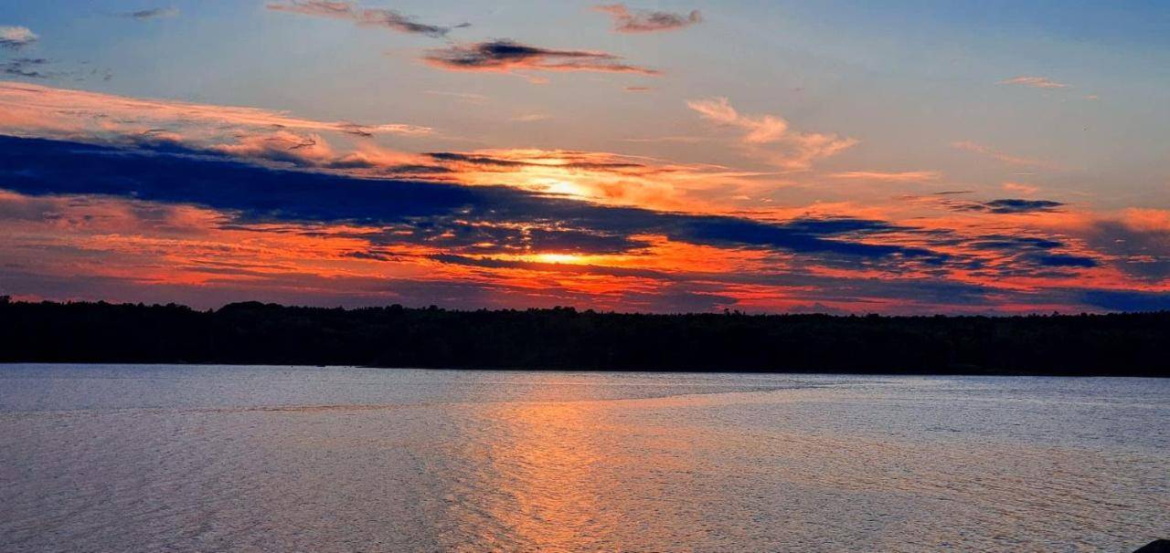 a sunset over a large body of water at K1ssick Cove Beach House family Acadia watersports in Ellsworth
