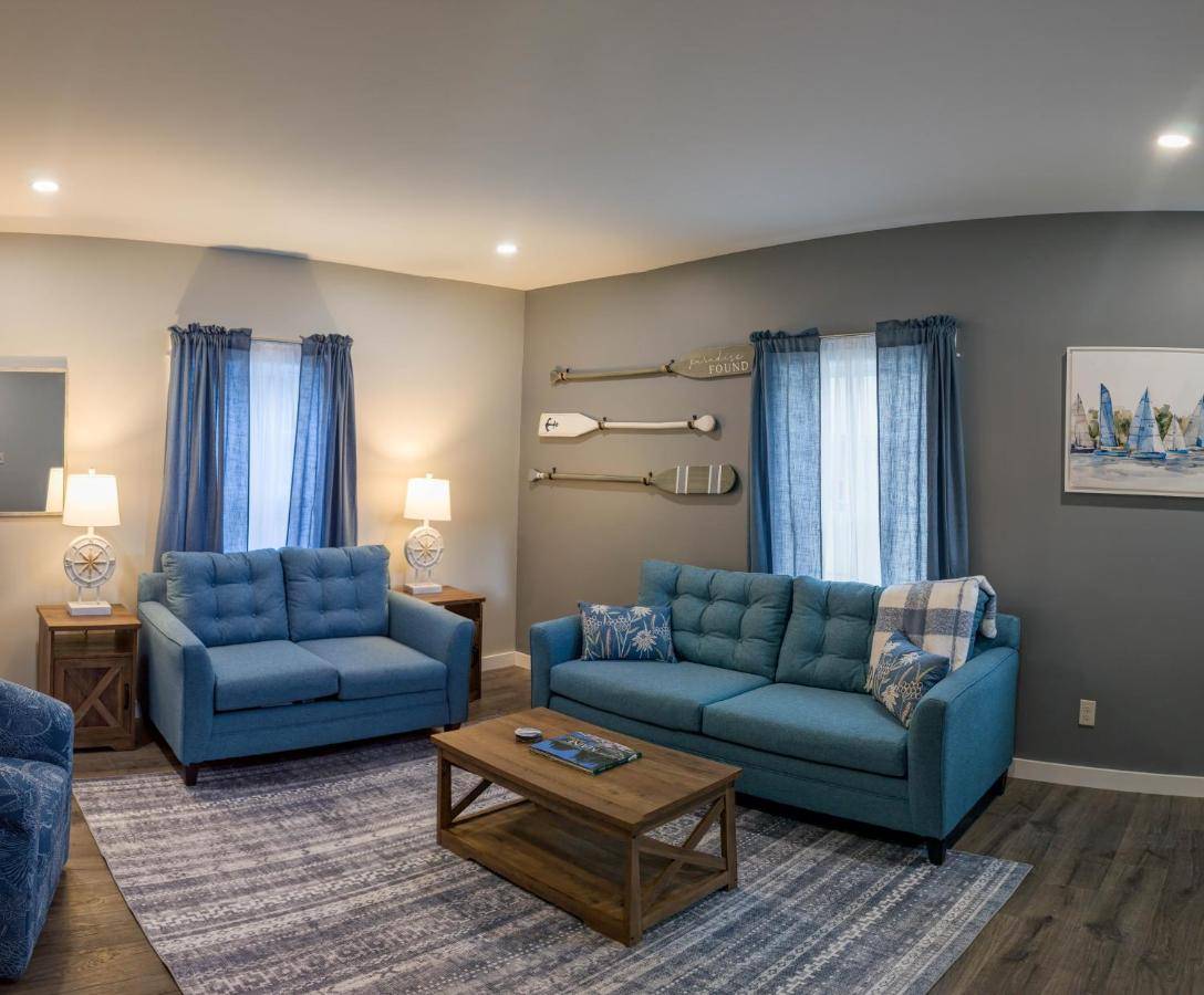 a living room with two blue couches and a table at Newly Renovated Acadia Apartment Mple Street in Ellsworth