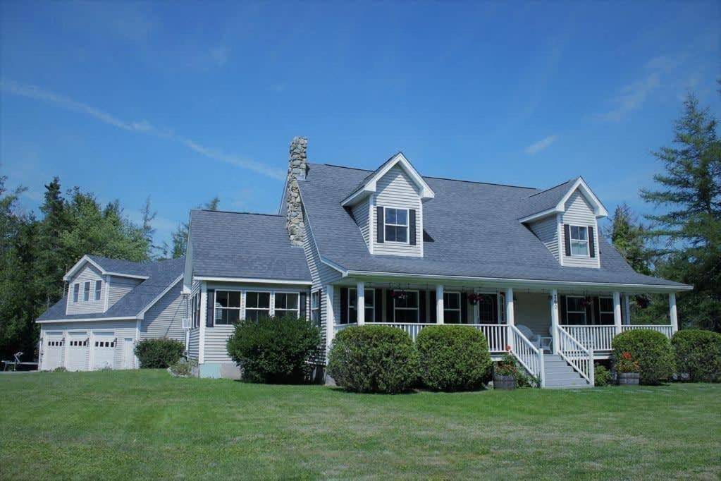 a white house with a gray roof at Pine and Sea Beach Retreat in Ellsworth