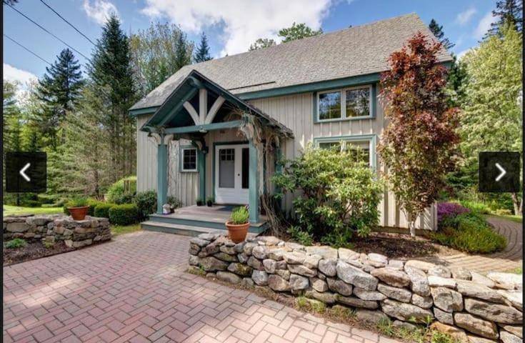 a house with a stone wall at Post and Beam Hikers Dream fire pit, 1dog in Ellsworth