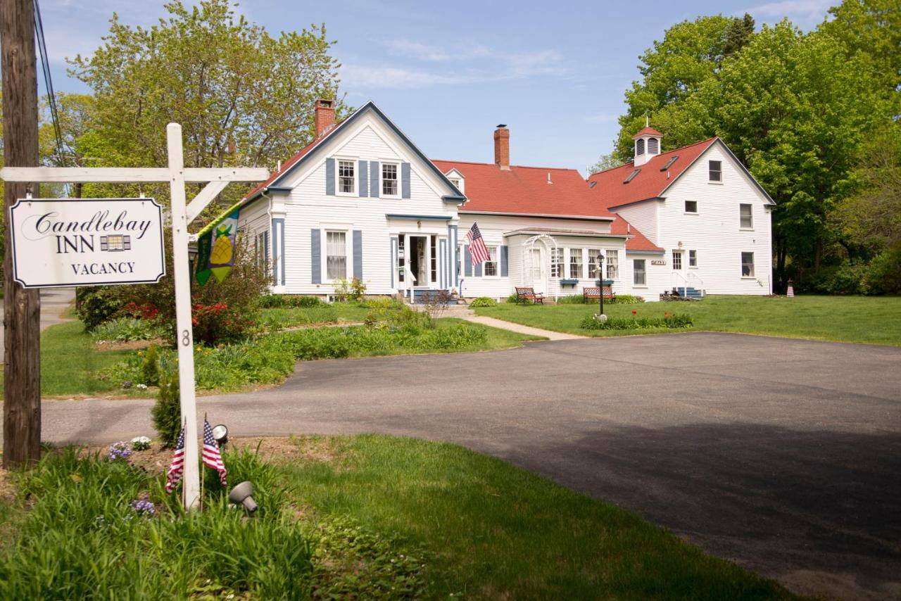 a cross in front of a white house with a sign at Candlebay Inn in Freeport