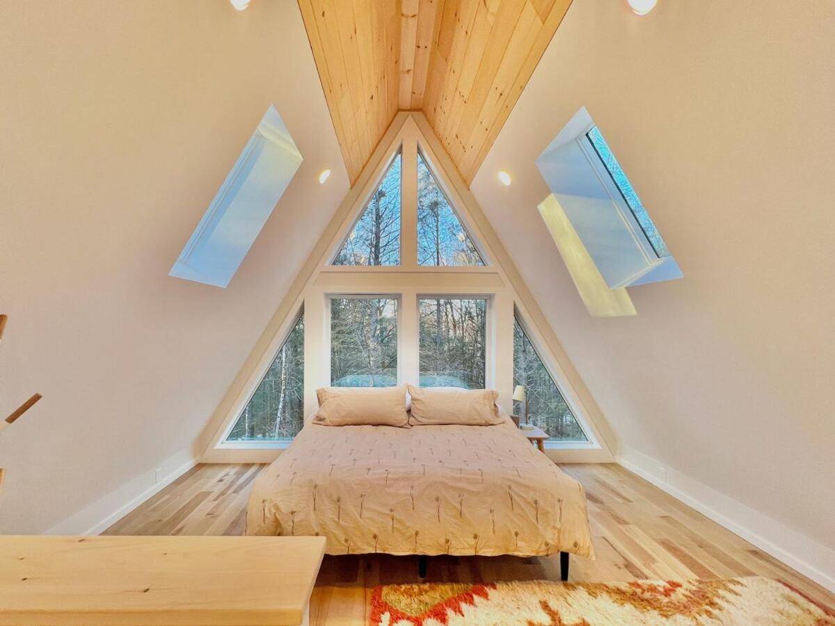 a bedroom with a bed and a large window at Chickadee A-Frame in Freeport