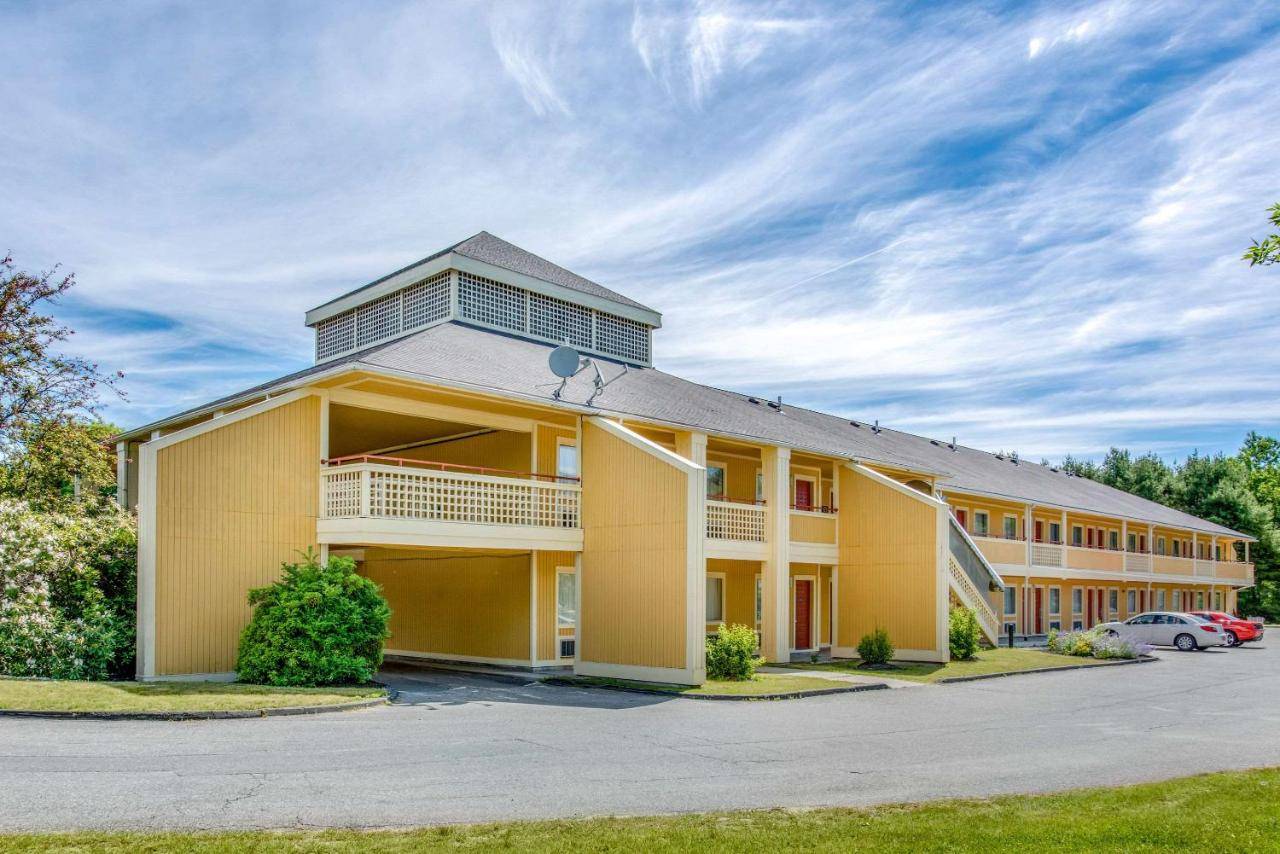 a large yellow building with a parking lot at Econo Lodge Freeport - Brunswick Area in Freeport
