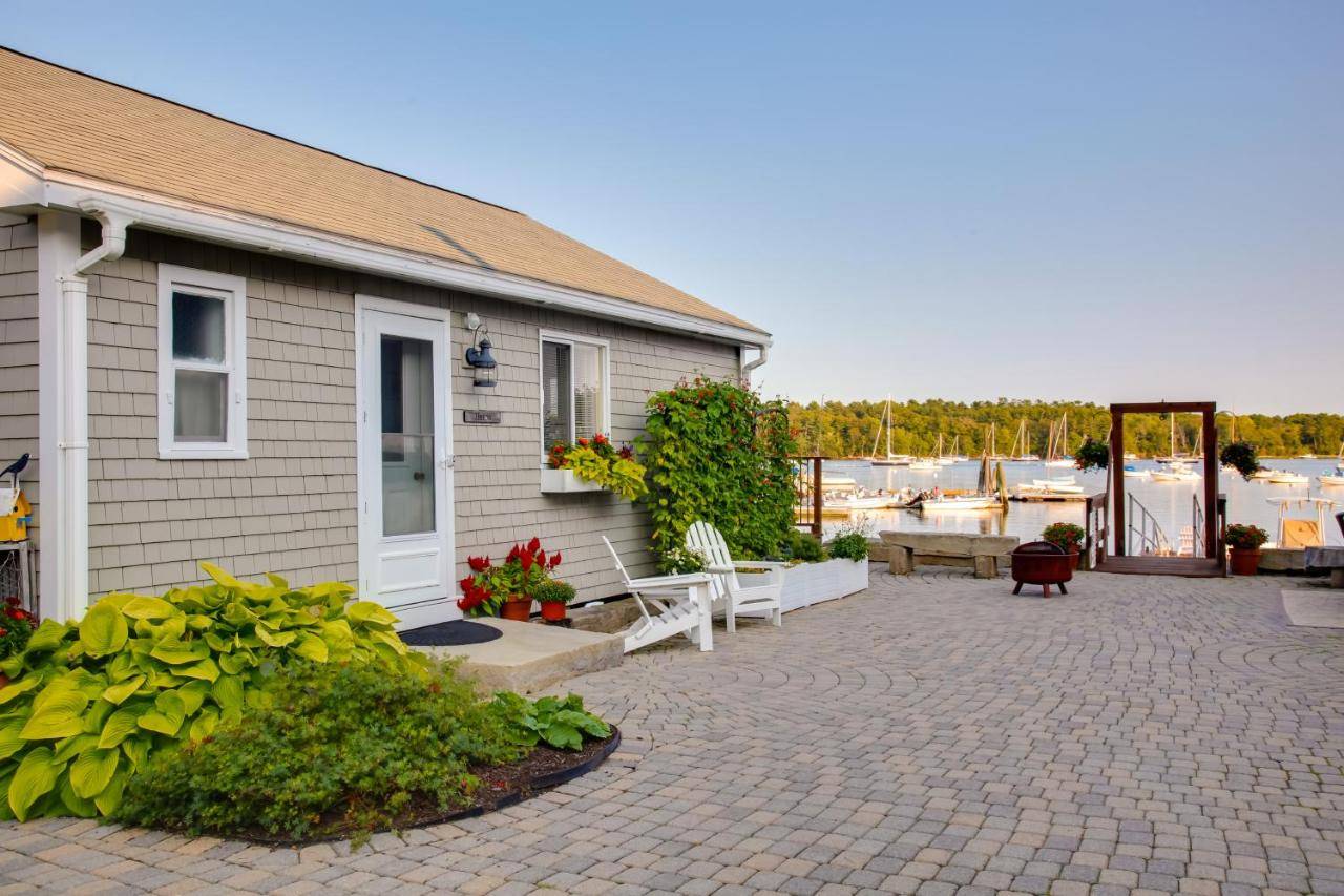 a house with a patio next to a building at Heron Cottage on Casco Bay with Deck and Boat Dock! in Freeport