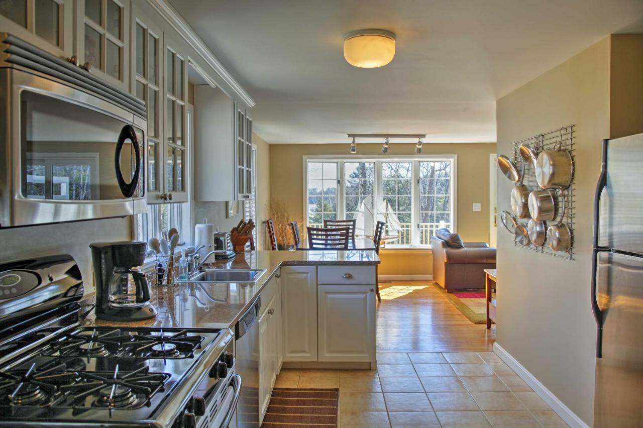 a kitchen with a stove and a counter top at Peaceful Waterfront Apt with Deck, 22 Mi to Portland in Freeport