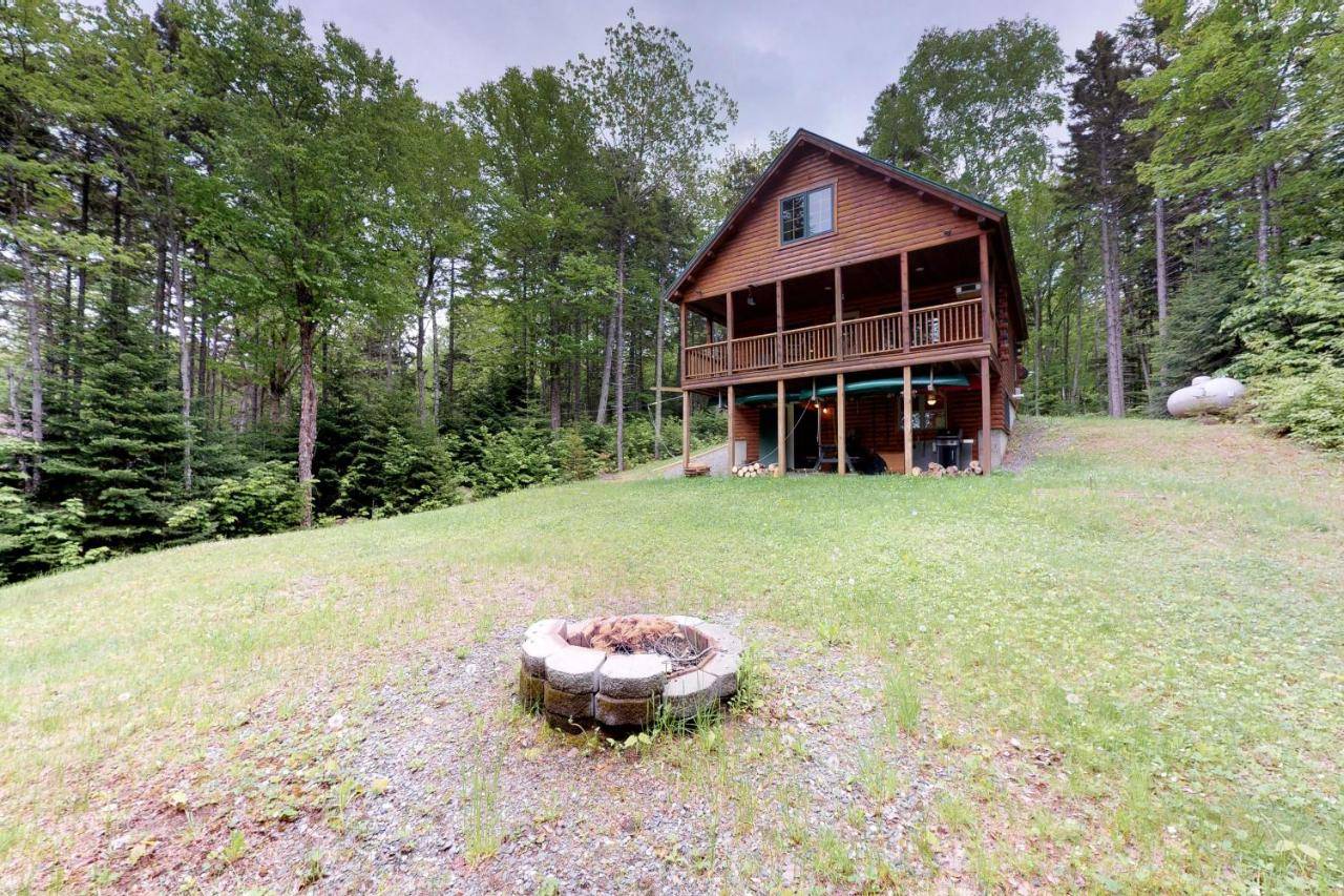 a house on a hill with a fire pit in the grass at Bobcat Cabin in Greenville