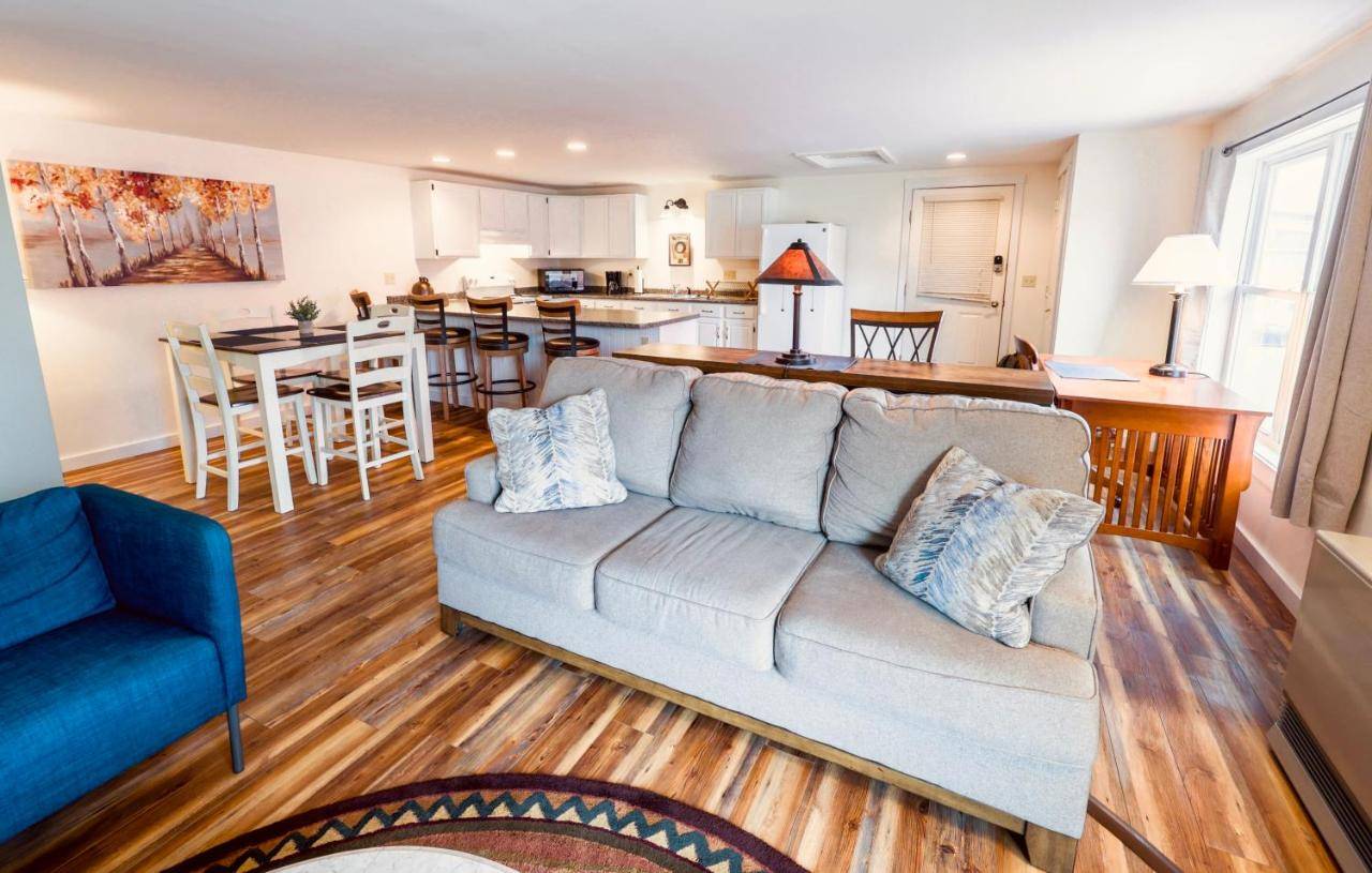a living room with a couch and a kitchen at Upscale Moosehead lake Suite downtown Greenville in Greenville