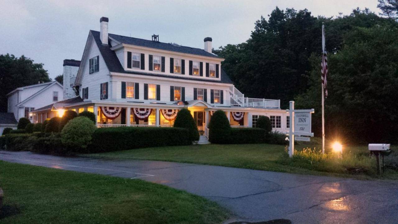 a large white house with lights in the yard at The Harpswell Inn in Harpswell Center