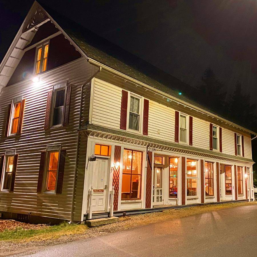 a large house with white doors and windows at night at Harbor House Hotel by Umaniii in Jonesport Maine in Jonesport