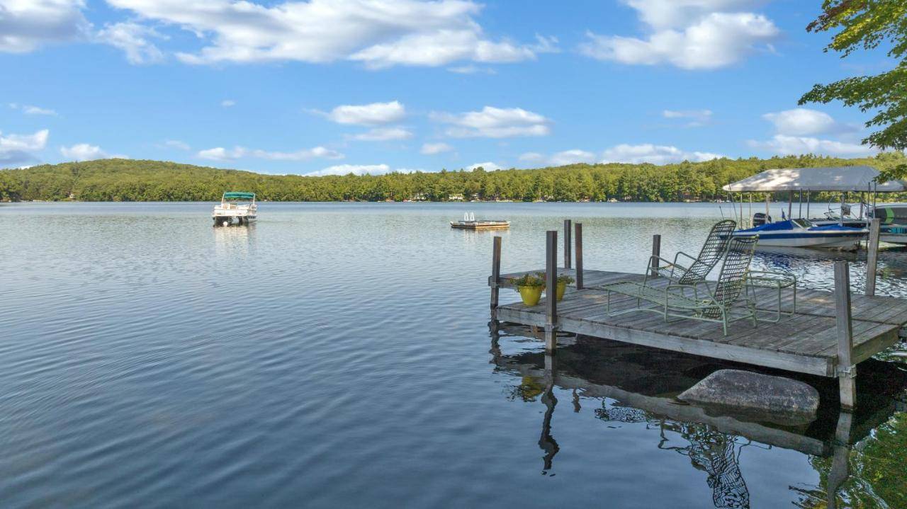 a dock on a lake with boats in the water at Family Friendly Kennebunk Pond Lakefront Retreat in Spang Mills