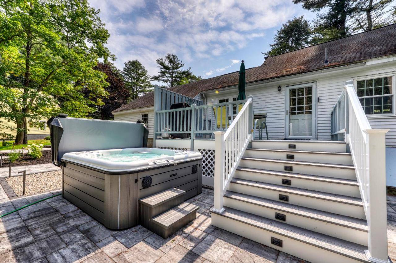 a backyard with a hot tub and a deck with a house at Kennebunk Family Cottage in Kennebunk