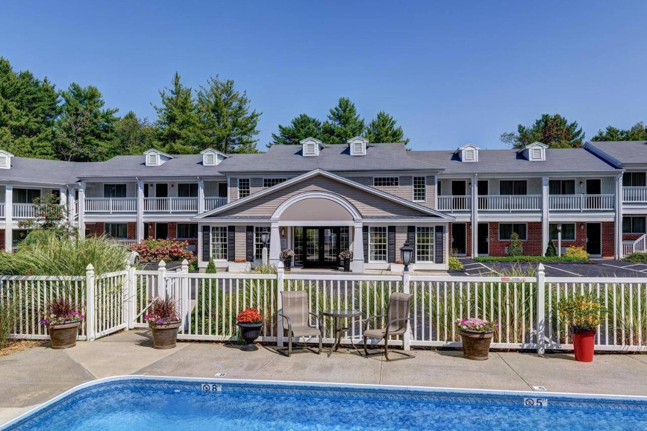a house with a pool and a fence at Port Inn & Suites Kennebunk, an Ascend Collection Hotel in Kennebunk