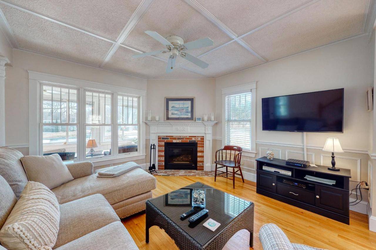 a living room with a couch and a flat screen tv at Quaint Bungalow in Kennebunk