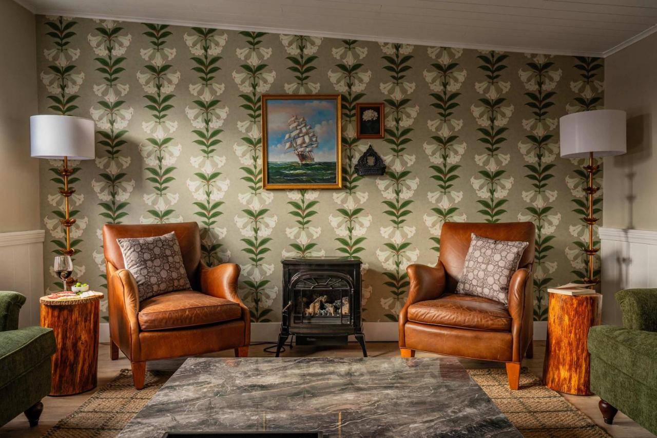 a living room with two chairs and a fireplace at The Curator's Retreat For 8 in Kennebunk