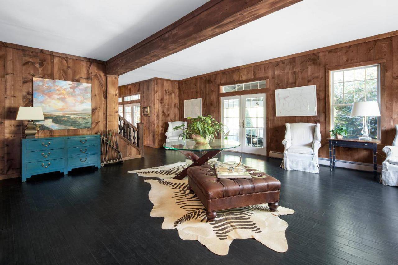 a living room with wooden walls and a glass table at Cape Arundel Inn - Club House in Kennebunkport